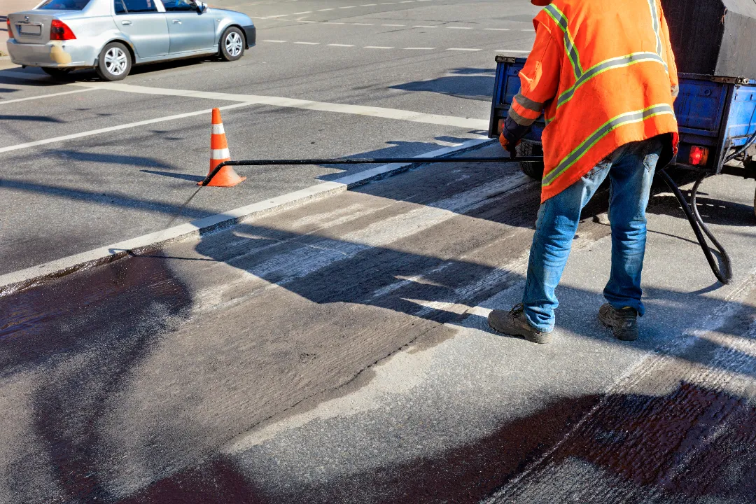 road-maintenance-worker-sprays-the-bituminous-mixt-2025-02-11-21-57-08-utc